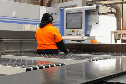 Supply Services LTD employee works in an industrial factory setting.