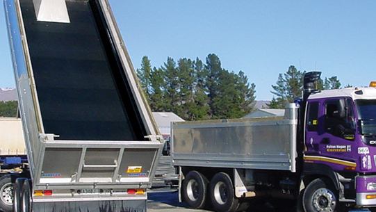 A large truck with a trailer parked alongside another.